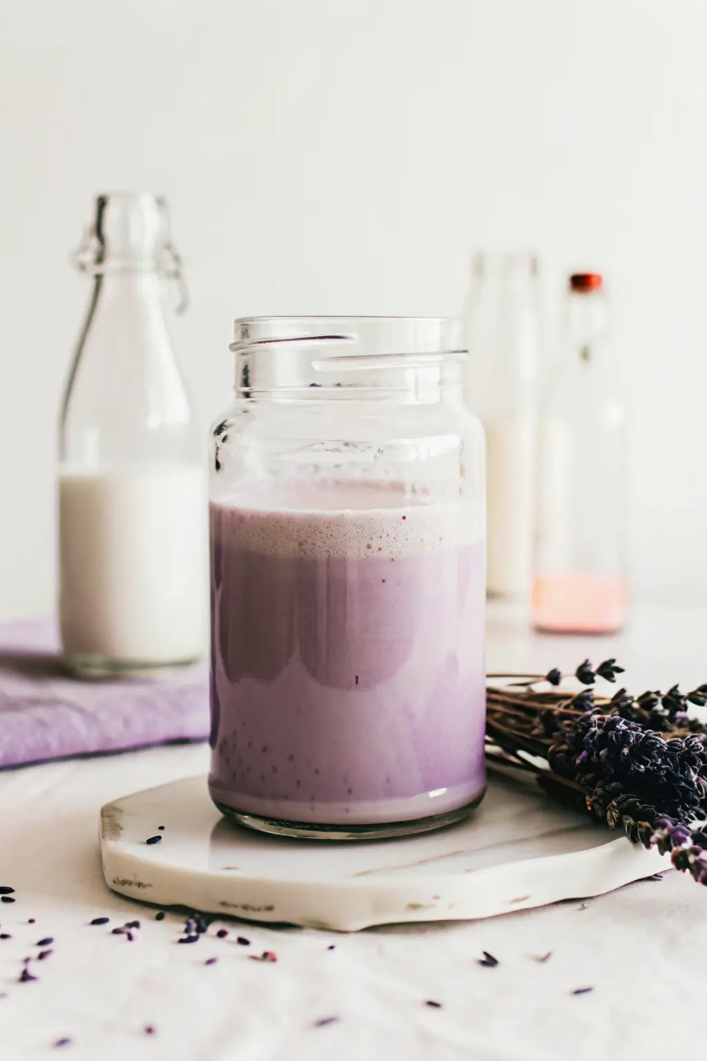Lavender cold foam poured over iced coffee in a clear glass