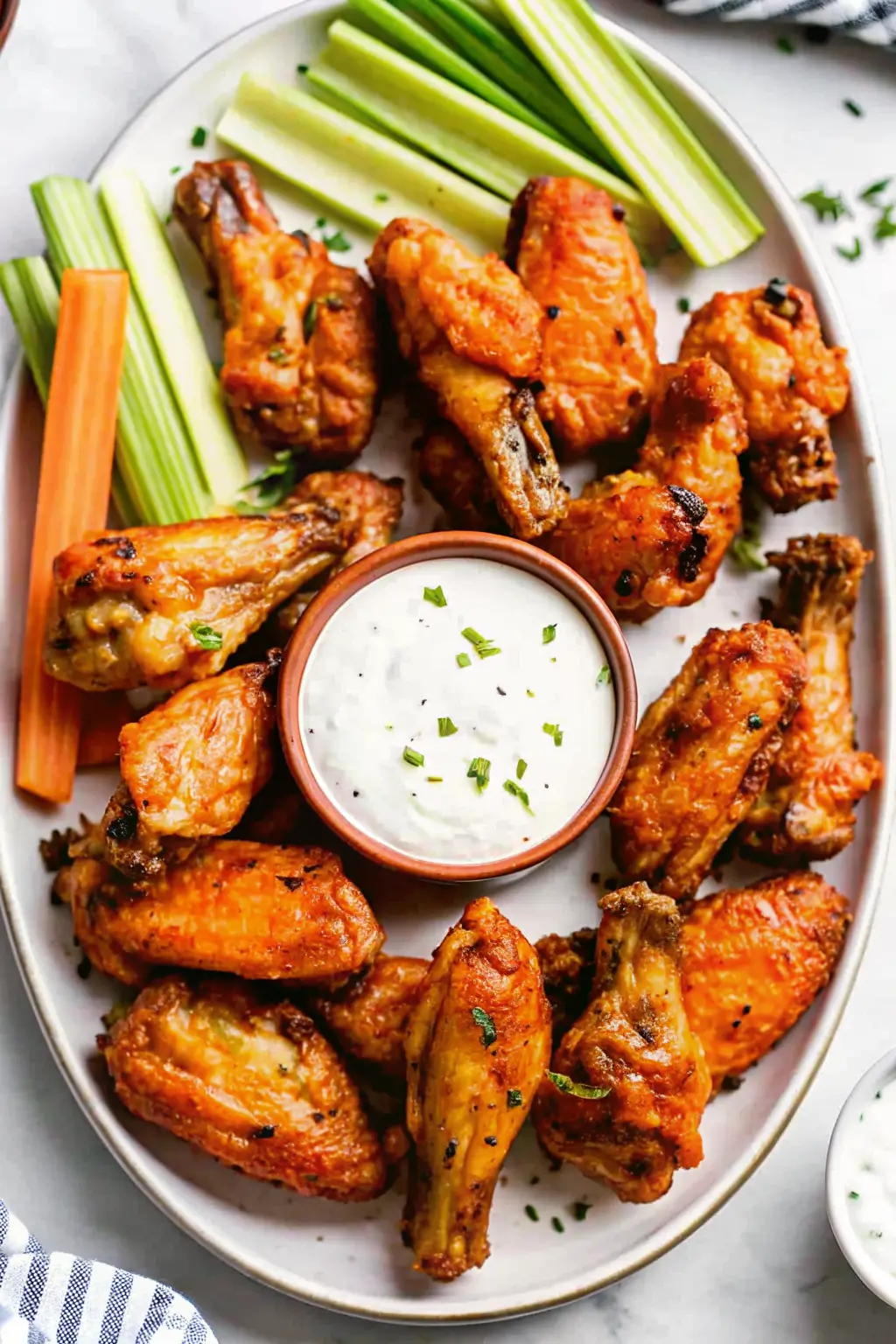 Best Buffalo Wings Recipe plated with sauce and celery sticks