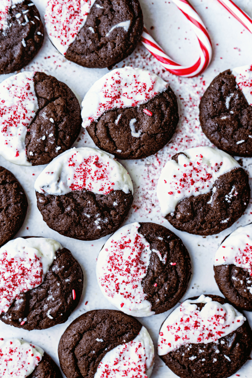 . Chocolate peppermint cookies topped with crushed candy canes on a holiday baking tray.