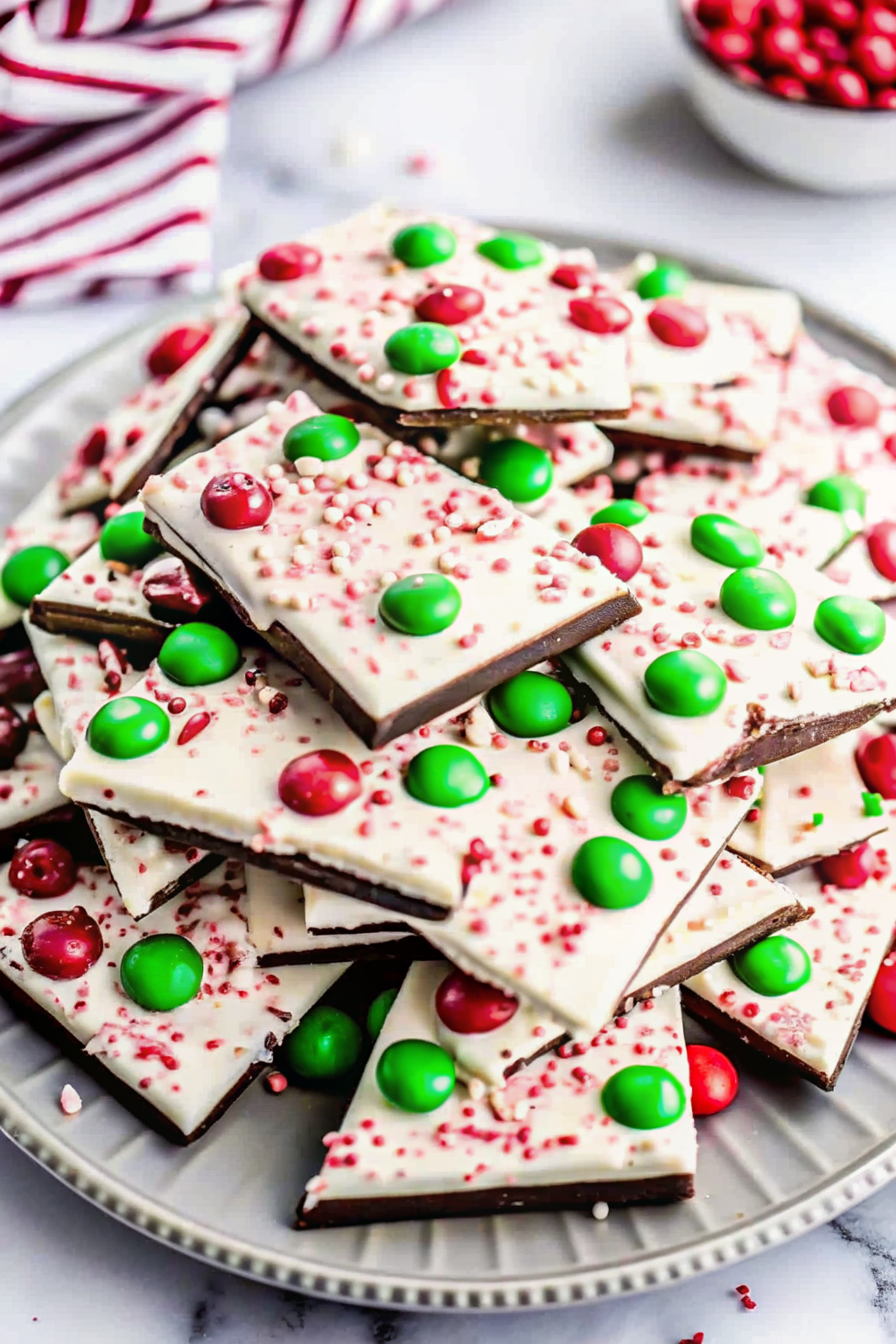 A rustic wooden board filled with shards of broken peppermint bark.