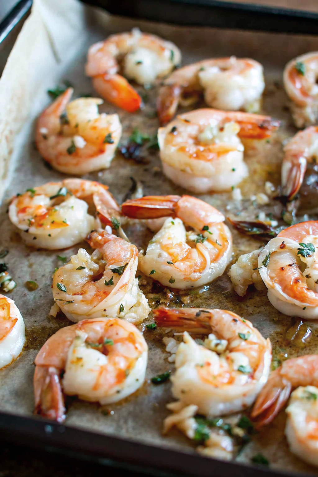 Cooked shrimp cooling in a bowl of ice water with lemon slices.