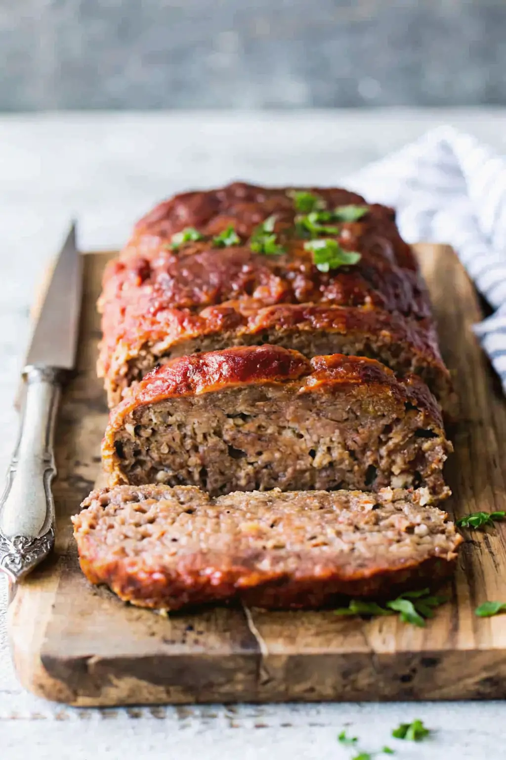 A whole, perfectly glazed, free-form ultimate meatloaf recipe sitting on a wooden board