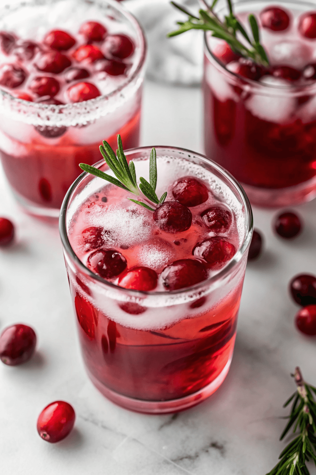 Pitcher of sparkling cranberry punch with cranberries and orange slices.