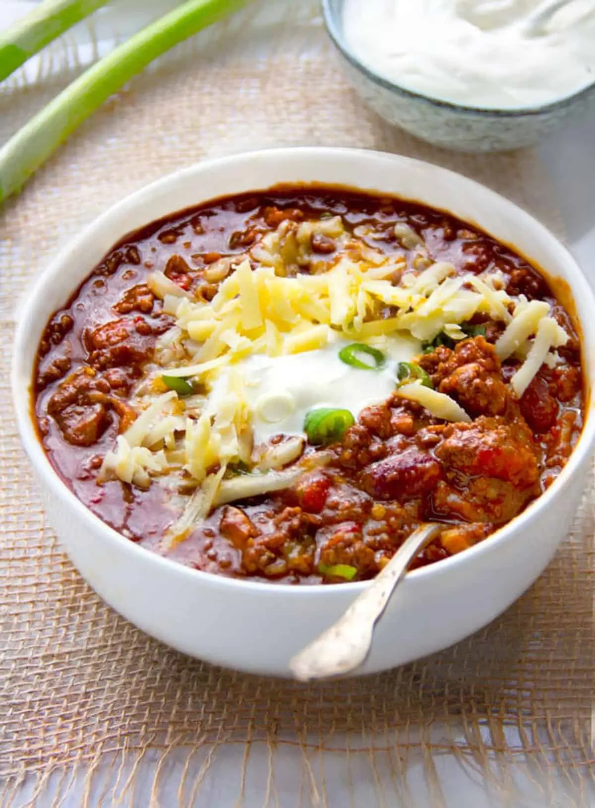 Bowl of hearty American Chili Escoffier topped with fresh herbs and served warm.