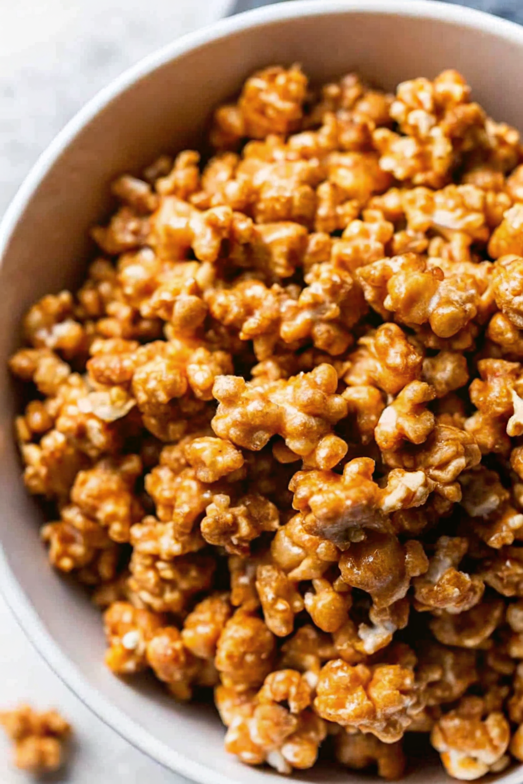 A large bowl filled with glossy, golden brown Caramel Popcorn