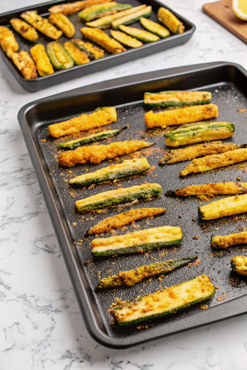  A baking sheet lined with parchment paper holding freshly baked zucchini fries