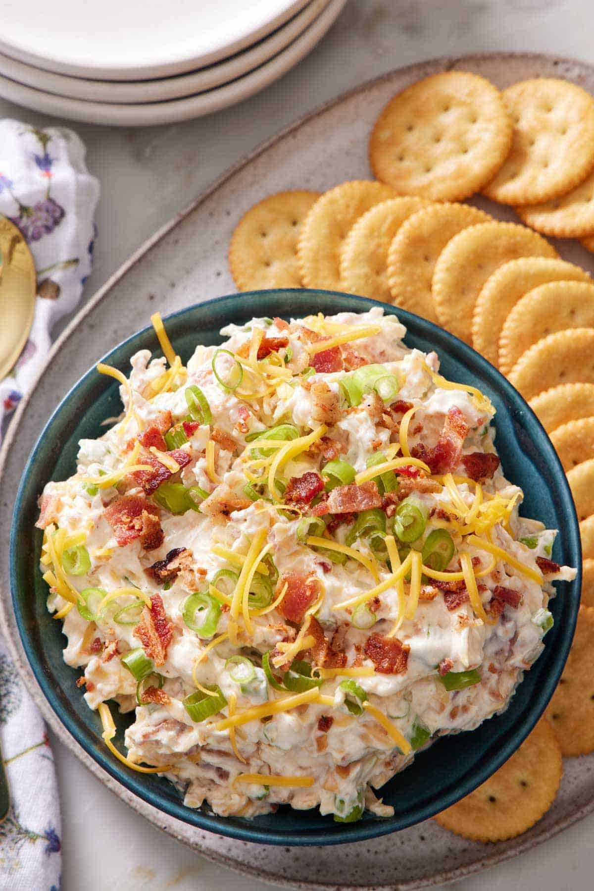 Slivered almonds toasting in a skillet next to crispy bacon crumbles
