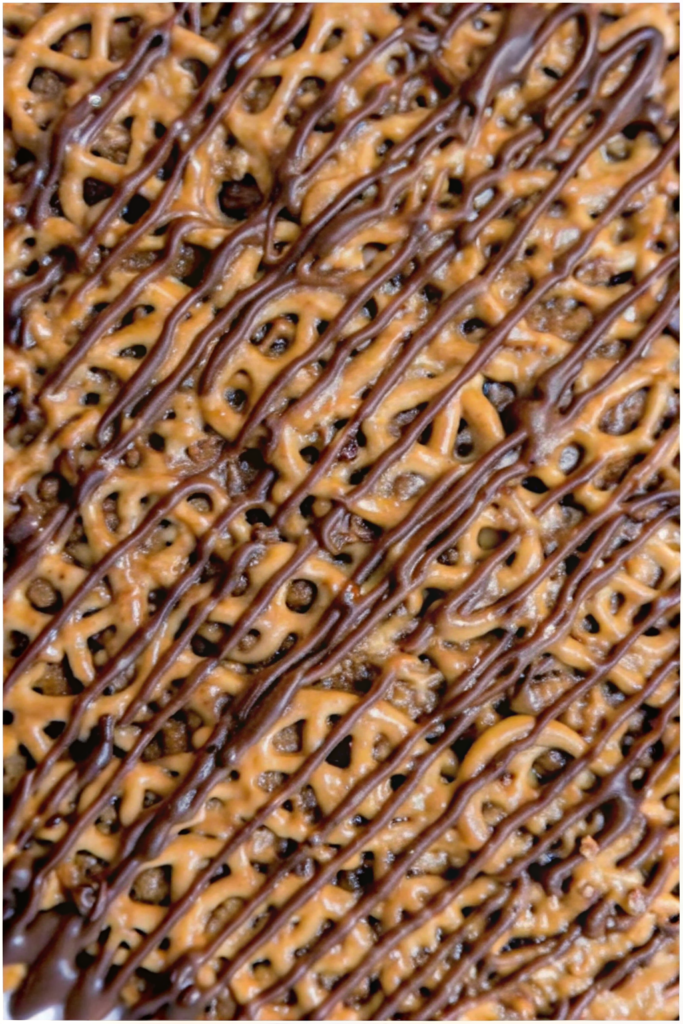 A wooden bowl filled with salted caramel pretzel bites topped with flaky sea salt