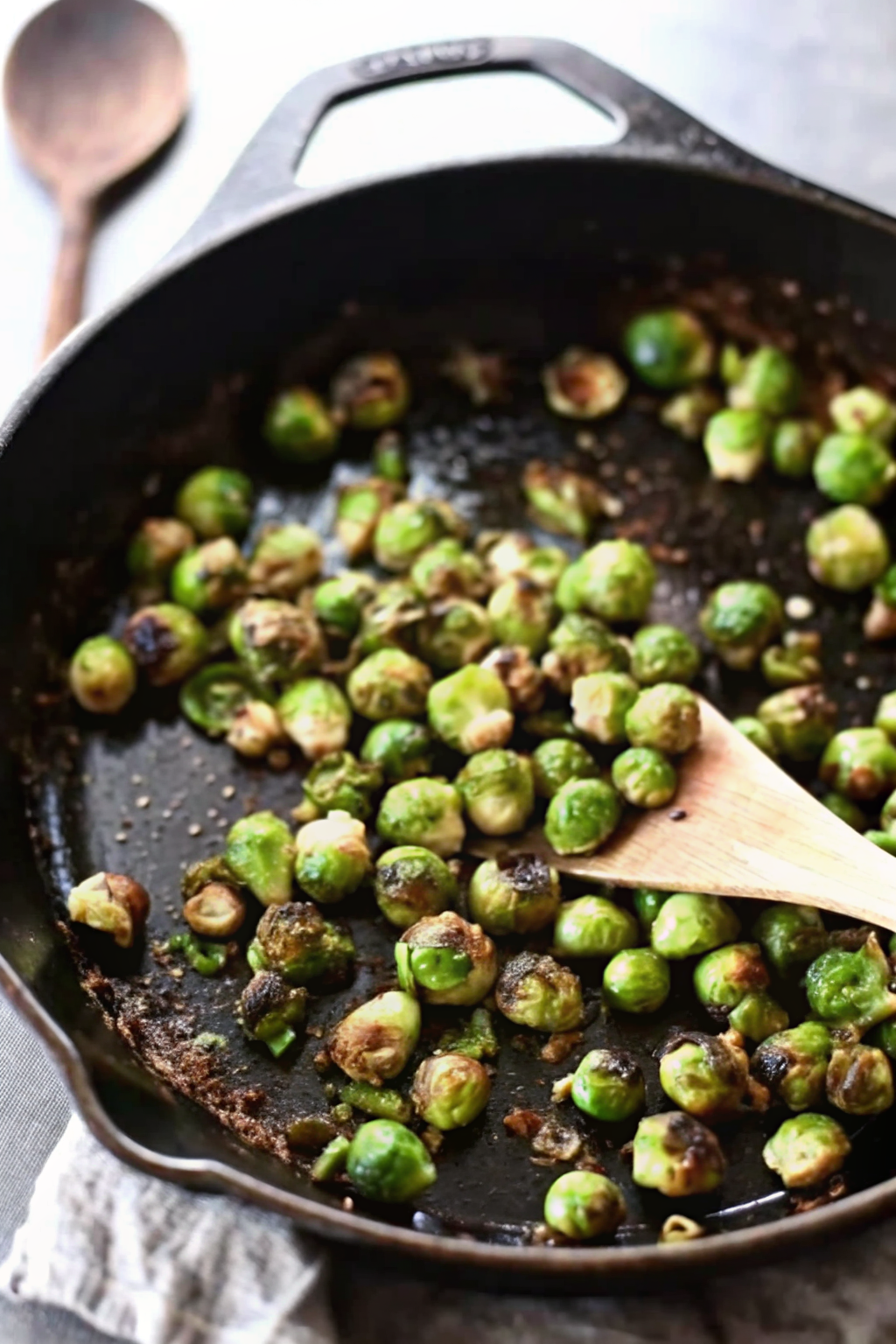 Slicing fresh Brussels sprouts in half on a cutting board.