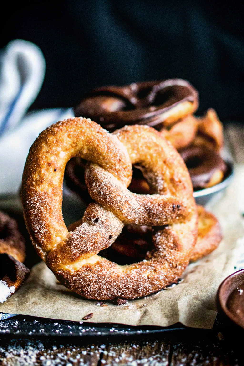 Stack of golden brown homemade pretzels with coarse salt on a wooden board. Internal Image 1