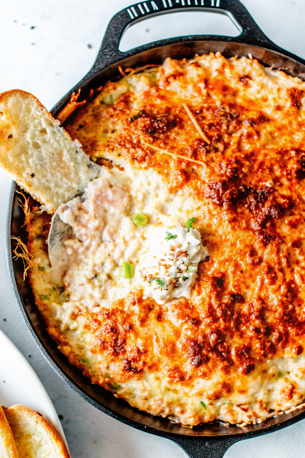 Scooping creamy crab dip onto a cracker