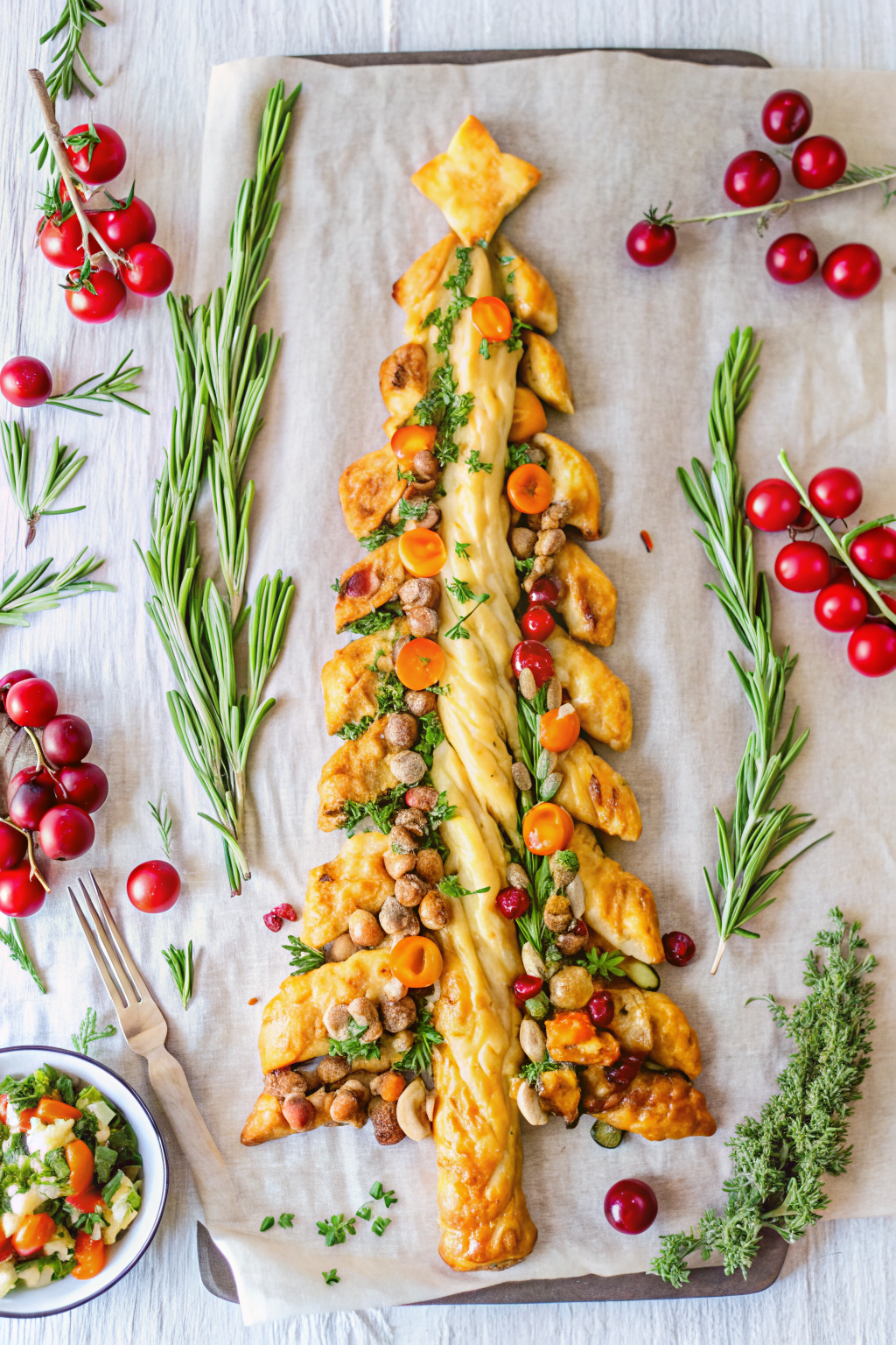 A golden brown Savory Puff Pastry Tree filled with pesto and garnished with pomegranate seeds