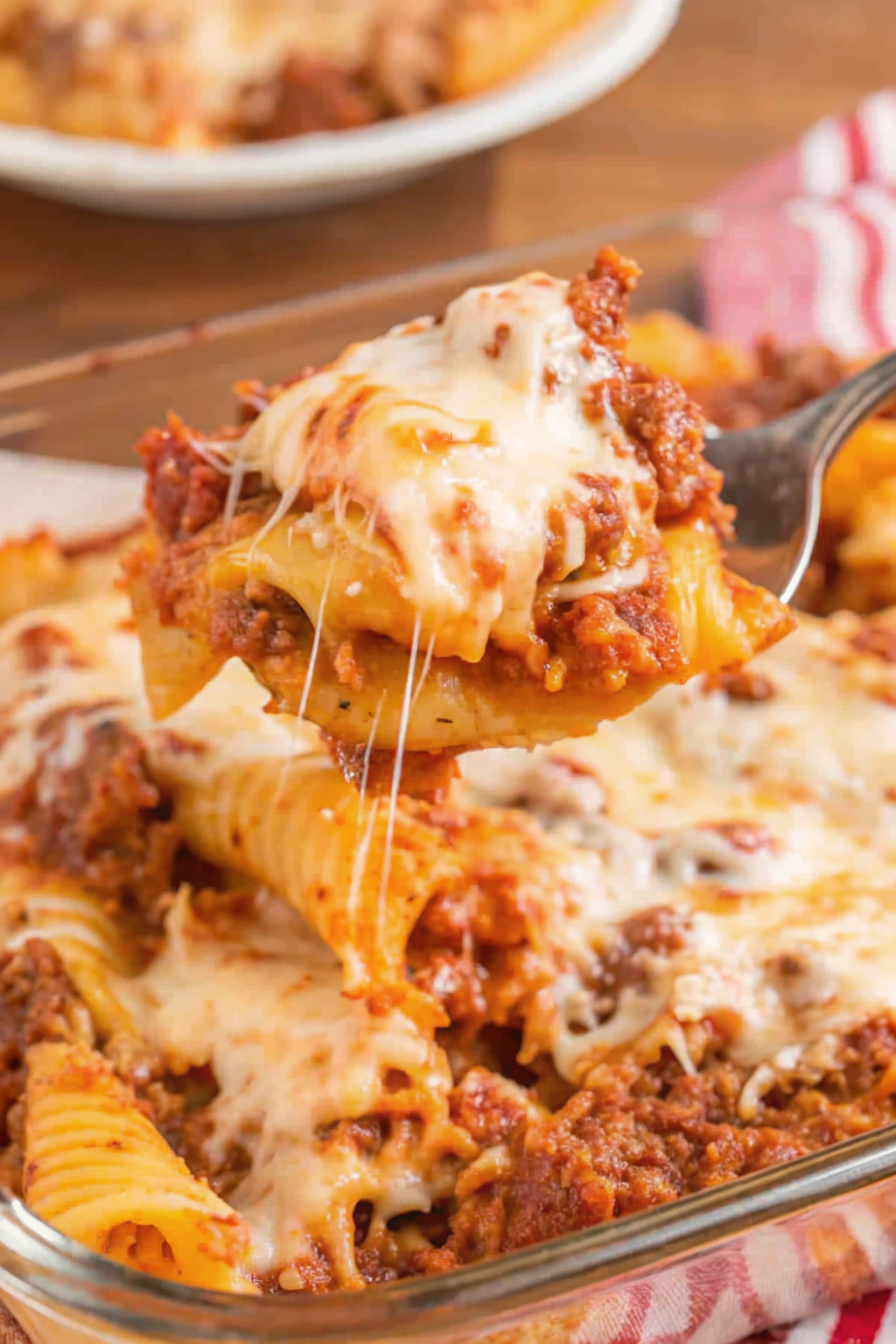 reshly baked STUFFED SHELLS in a white bowl with a golden crust and fresh basil garnish.